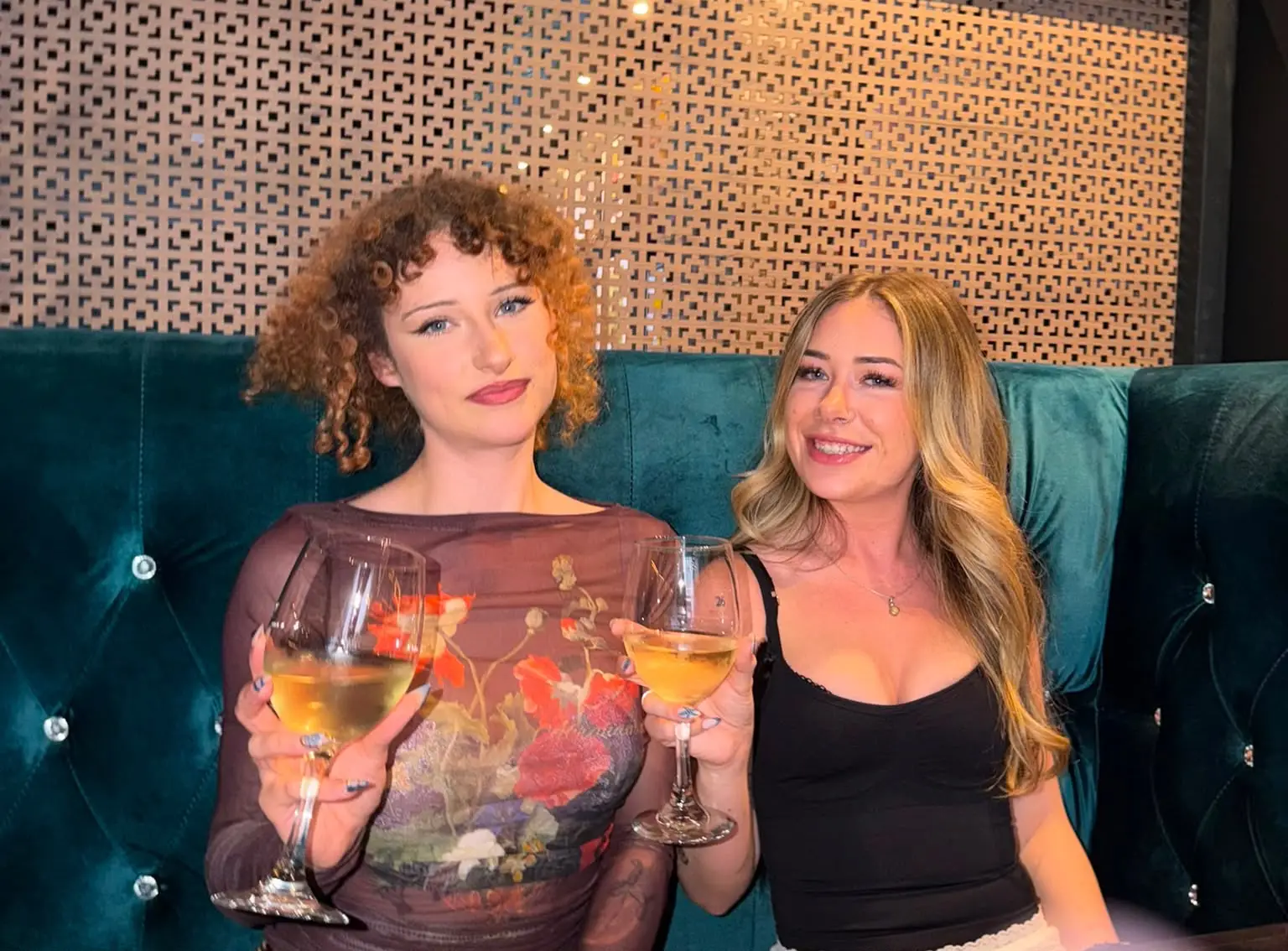 Two women smiling and holding wine glasses
